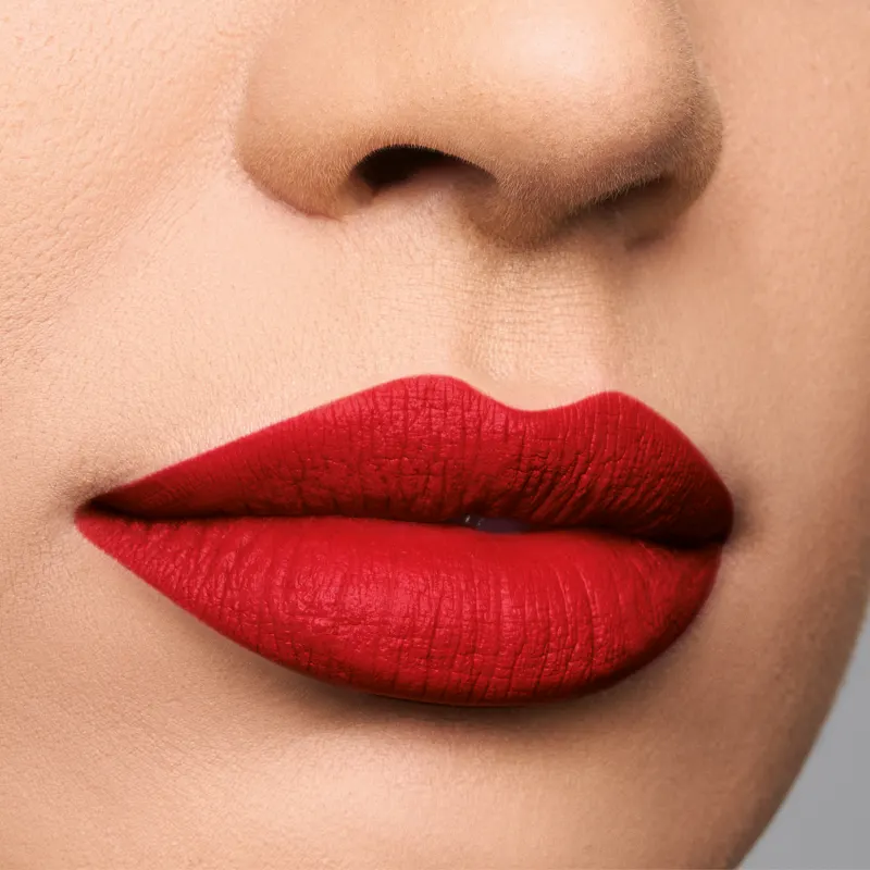 Imagem de um rosto feminino em close-up, evidenciando os lábios com batom semi matte vermelho vibrante.