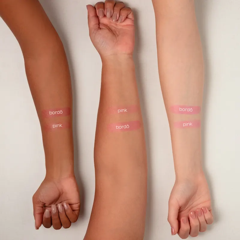 Três braços femininos de cores de peles diferentes e, em cada um deles, duas amostras de cores do blush jelly Toda Fresh Quem Disse, Berenice? mostrando como eles ficam na pele.