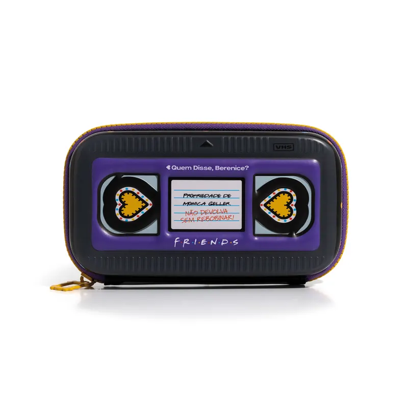 Acessório com design inspirado na série de TV "Friends". Imita fita VHS com uma mensagem sobre não devolver algo sem recarregar. Possui detalhes em roxo e amarelo, com ícones de coração em ambos os lados.