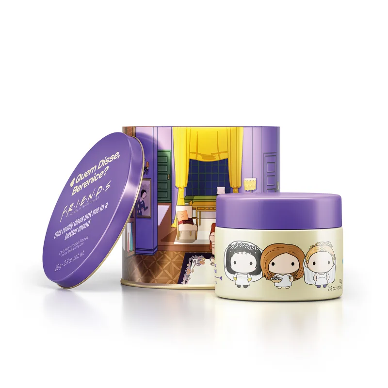 Recipiente1 em forma circular, com tampa roxa e decoração de personagens. Embalagem com texto "Quem Disse, Berenice?" em fundo roxo. Ao fundo, recipiente 2 com ilustrações de personagens em fundo claro. Ambiente interno com móveis e cortinas visíveis.