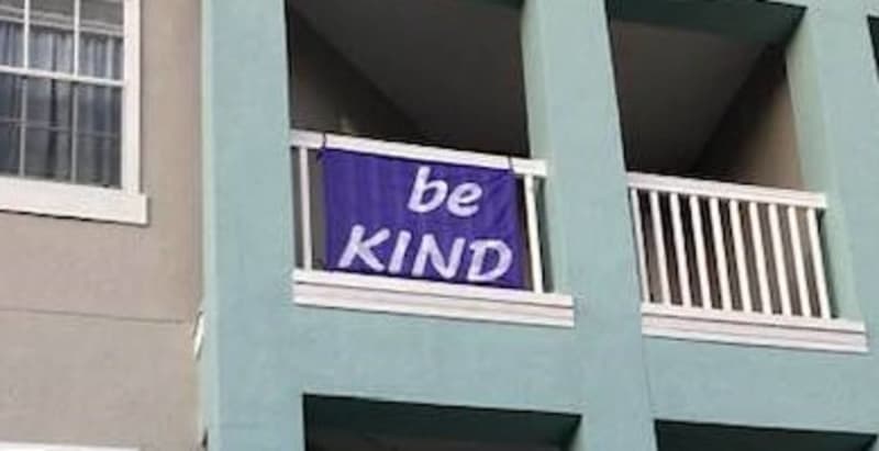 Customer photo: a purple Be Kind flag hanging from a balcony