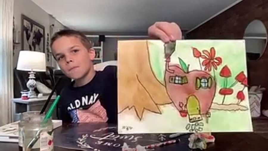 Child showing a colorful drawing of a whimsical house and flowers.