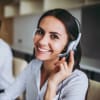 A BEMER customer service employee smiles while answering a call with her headset