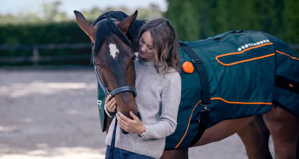 Woman standing with a horse wearing the BEMER horse blanket
