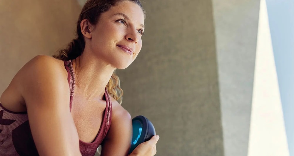 Treatment – woman outdoors using the B.Spot Evo on her shoulder