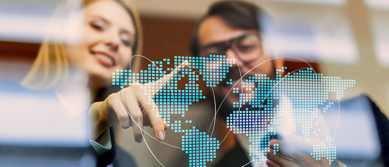 Woman shows man a dot globe on a glass panell