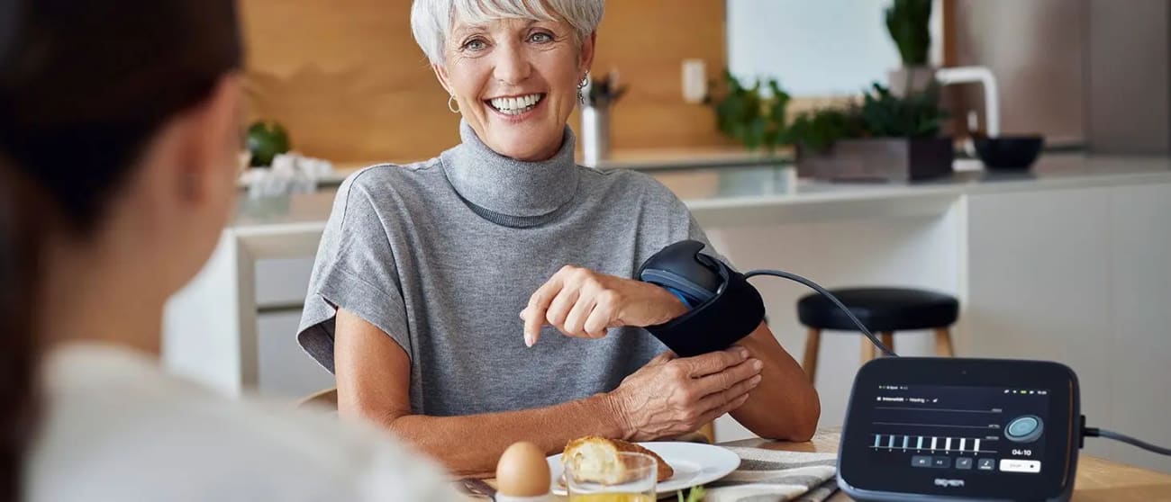 Woman using the BEMER Premium-Set Evo during breakfast.