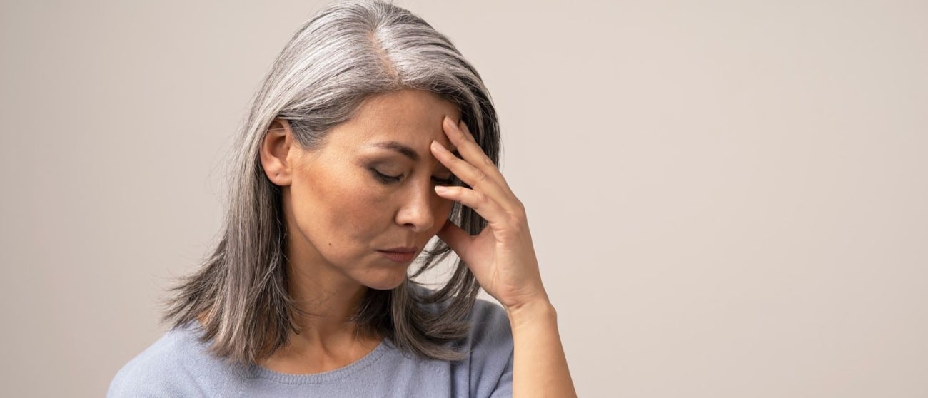 Woman holding her forehead due to stress
