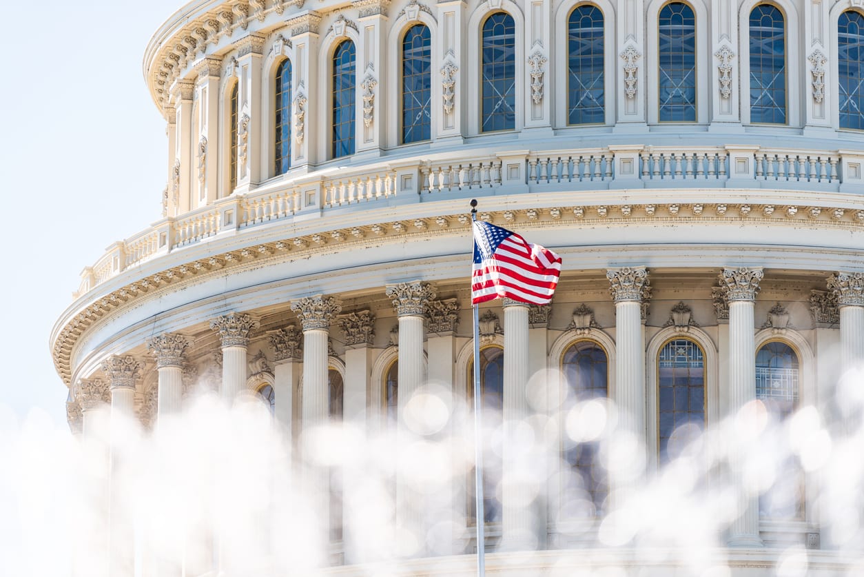 US Congress dome closeup with background of water fountain splashing, American flag waving in Washington DC, USA closeup on Capital capitol hill, columns, pillars