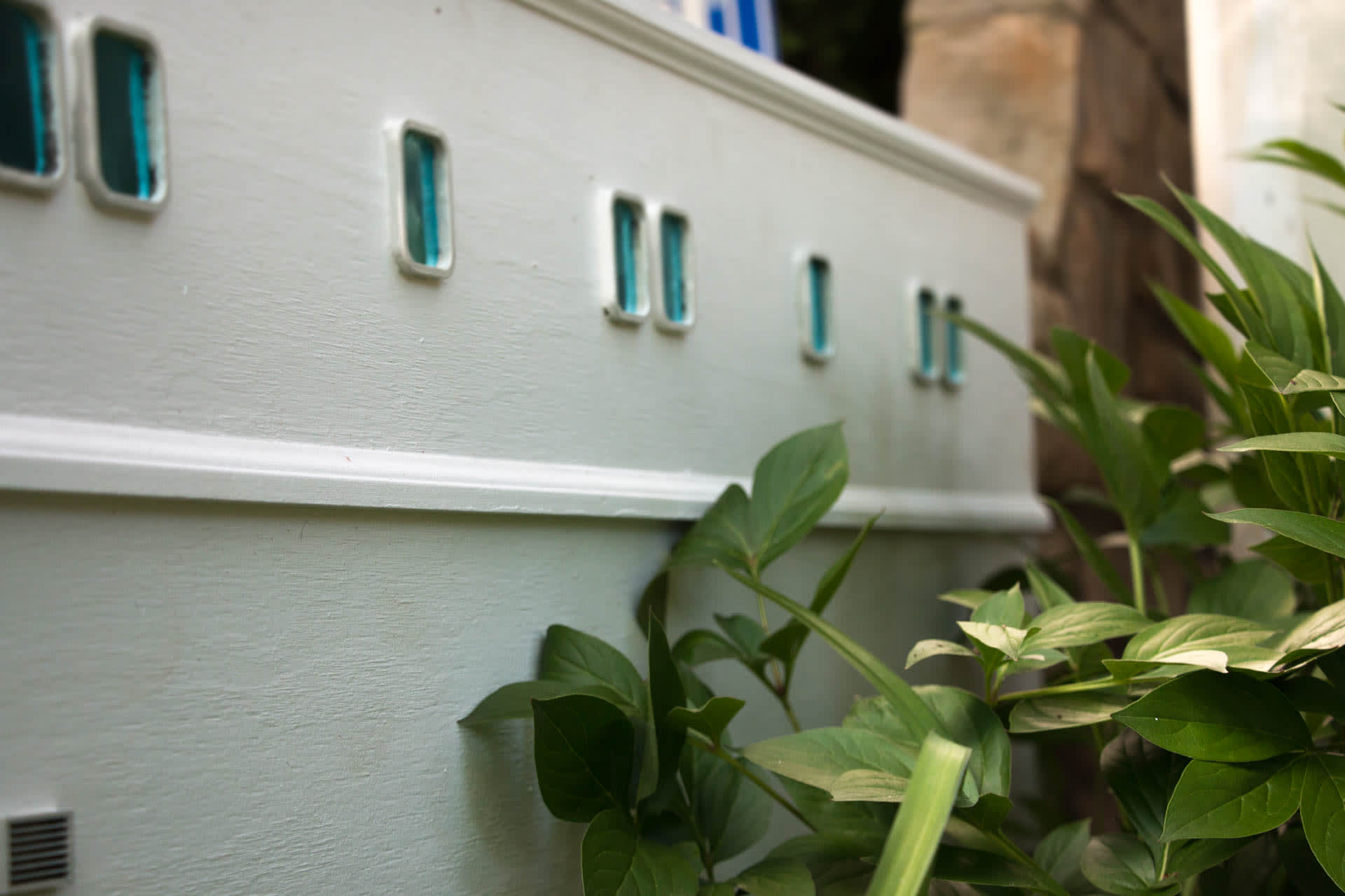 Tin blue windows on the side of a miniature building