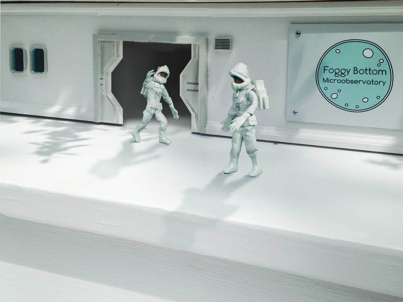 Two small astronauts entering a white laboratory