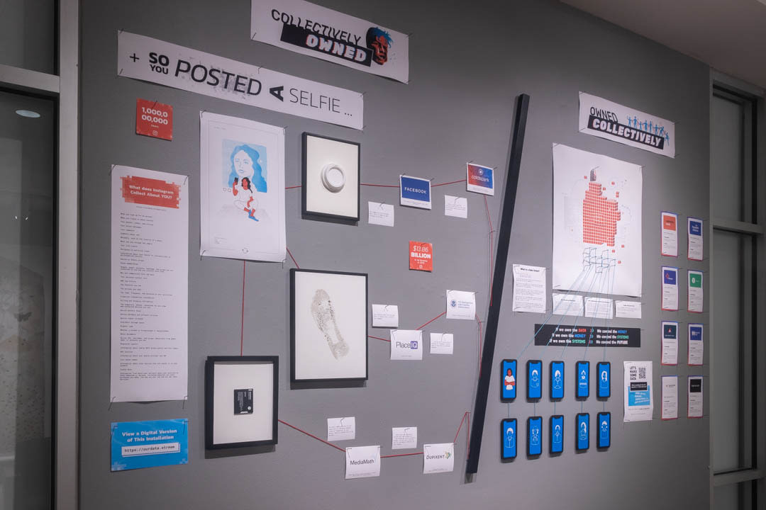 A wall of papers and framed objects in a gallery