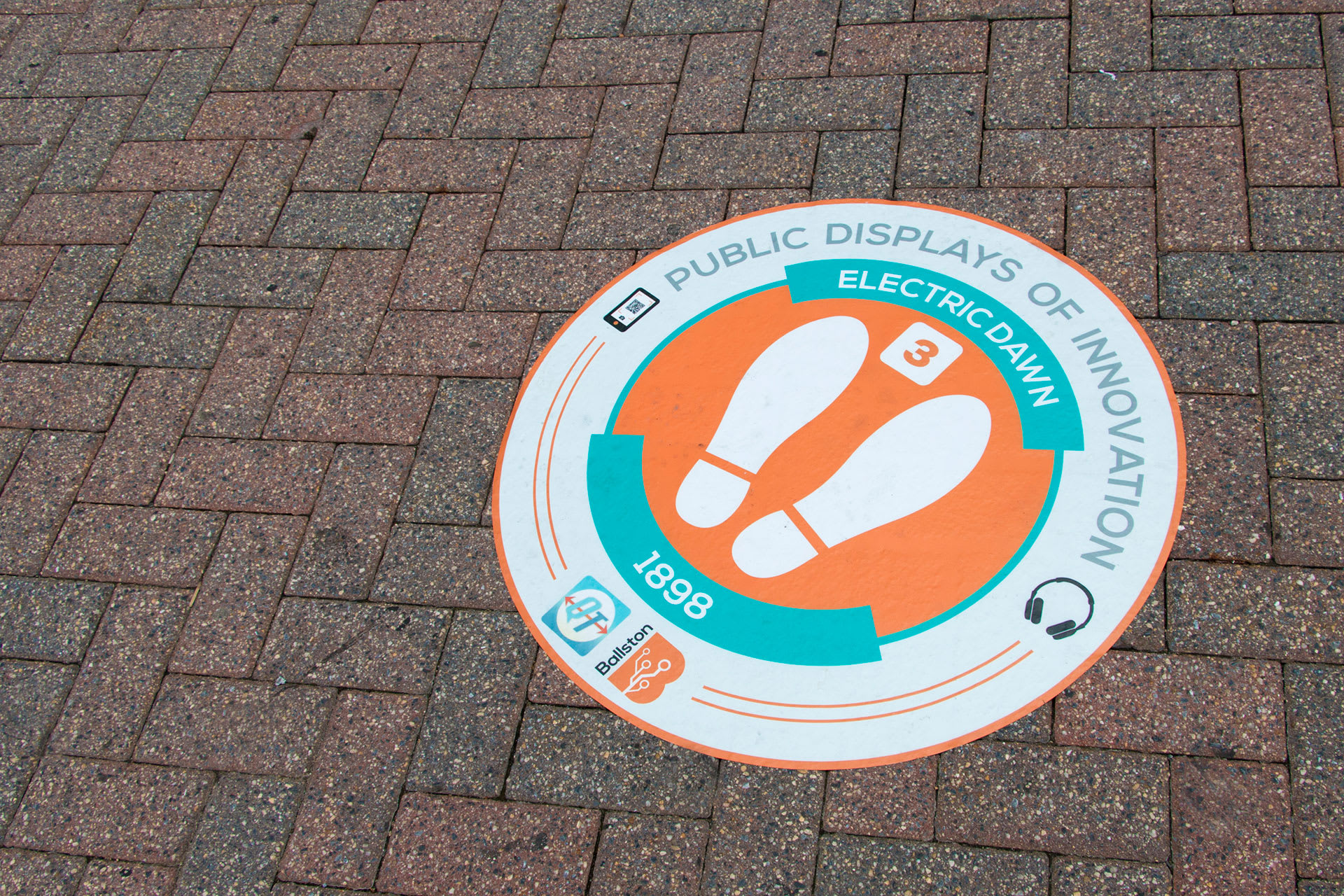 A round sidewalk decal with two footprints