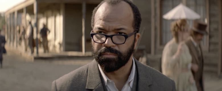 A black man in glasses in an old west street