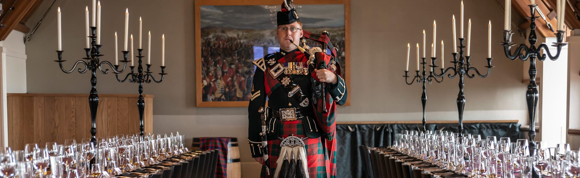 A person play bagpipes in an event space at Edinburgh Castle