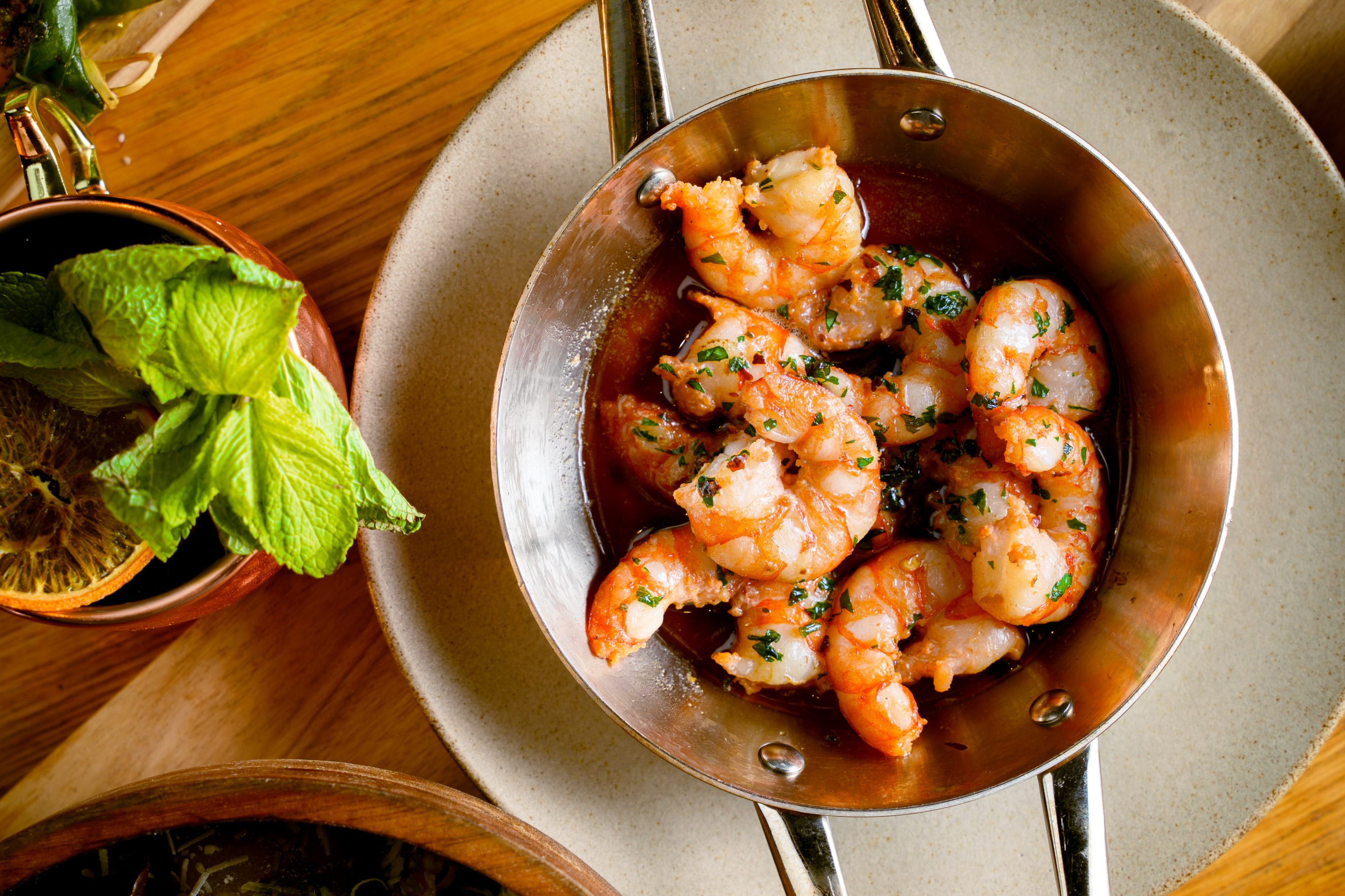 Rosa og hvite marinerte reker i et oljebad i en liten panne
