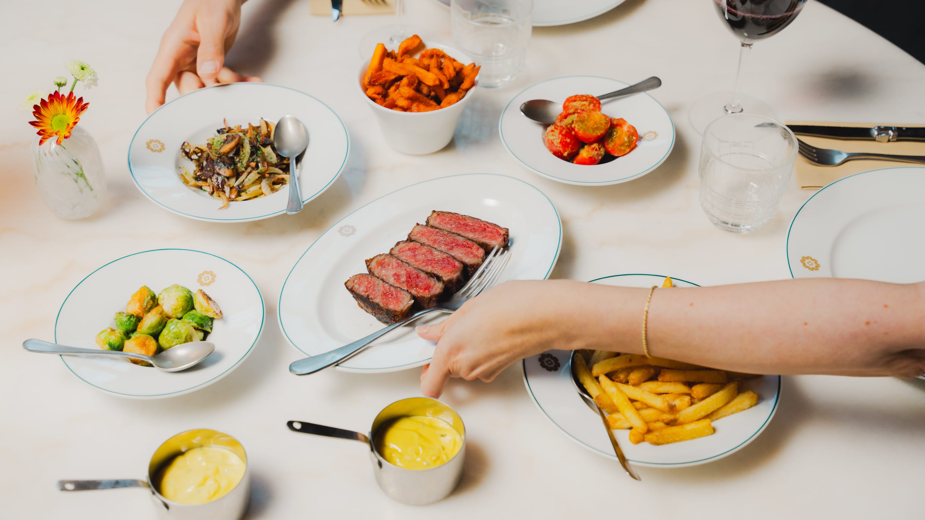 Sideretter, biff, tomater, fries på et bord på Engen Steakhouse