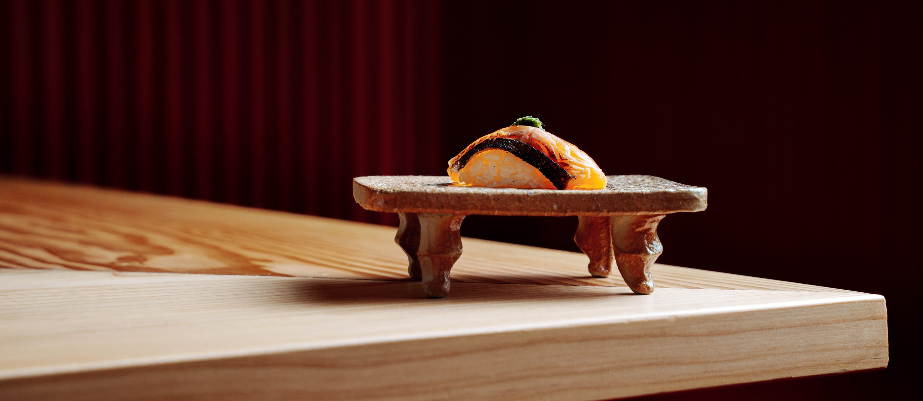 En bit sushi på tallerken på bordet på Omakase