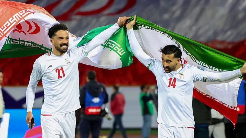 Iran players Omid Norafkan and Saman Ghoddos celebrate after a qualifying match in 2025