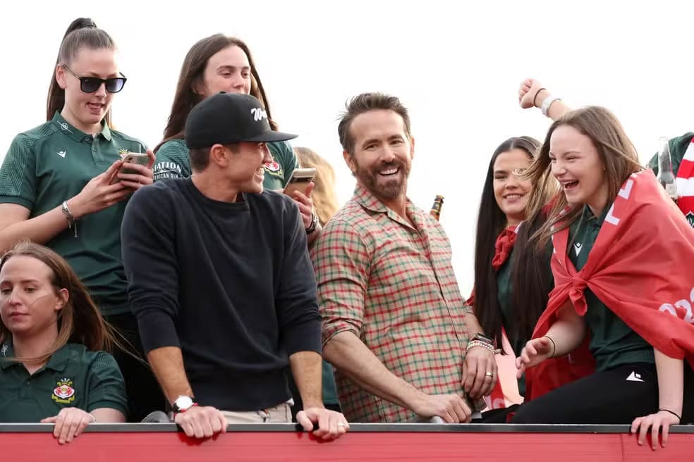Rob McElhenney e Ryan Reynolds em desfile em carro aberto do Wrexham