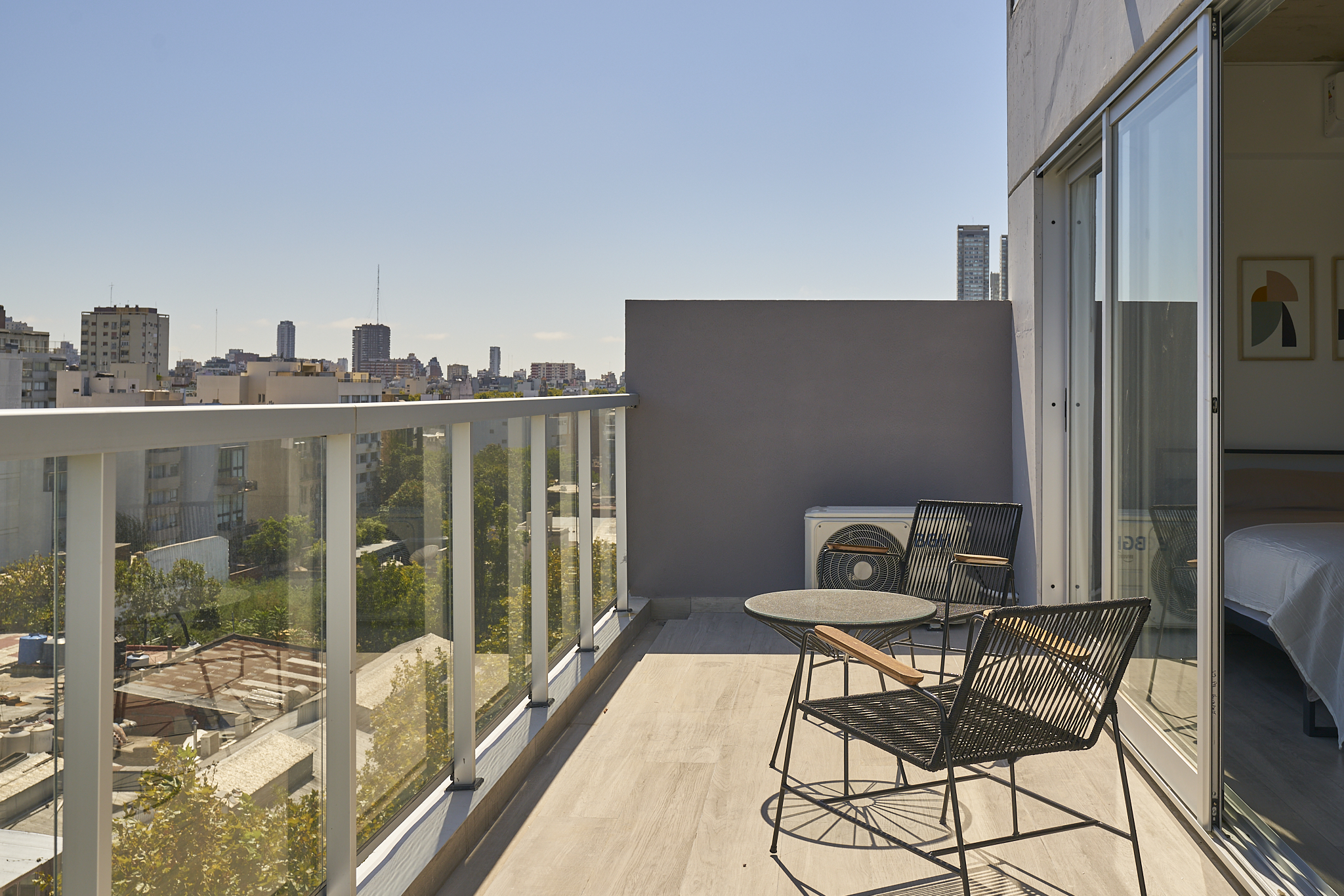Balcony with two chairs, a small table and a Buenos Aires city view