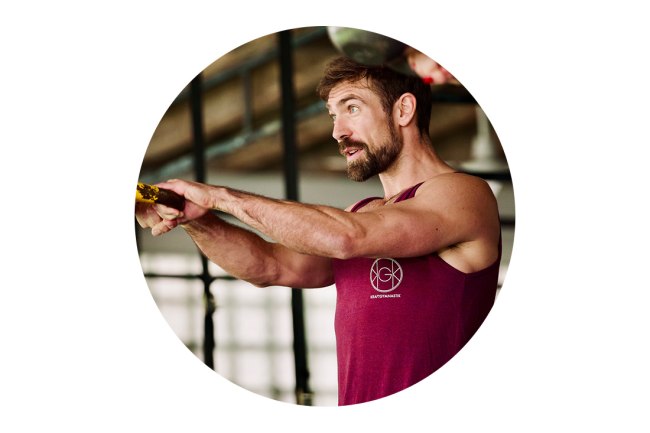 Ein Porträt von Olli Dehmel. Er führt einen Kettlebell-Swing aus.