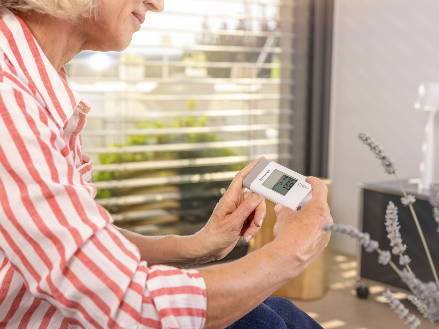 Frau verwendet mobiles EKG Gerät von Beurer