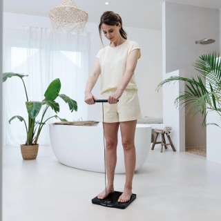 Une femme se tient debout sur la balance diagnostique 990 WIFI et teste l'analyse professionnelle complète du corps comprenant jusqu'à 25 données corporelles Une femme se tient debout sur la balance diagnostique 990 WIFI et teste l'analyse professionnelle complète du corps comprenant jusqu'à 25 données corporelles