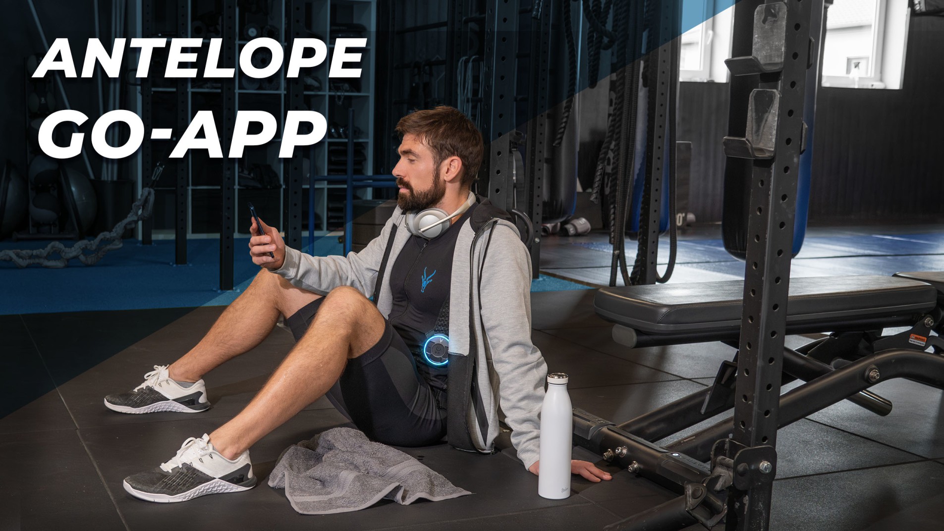 Een man gebruikt de Antelope Go-app voor EMS-training in de sportschool.