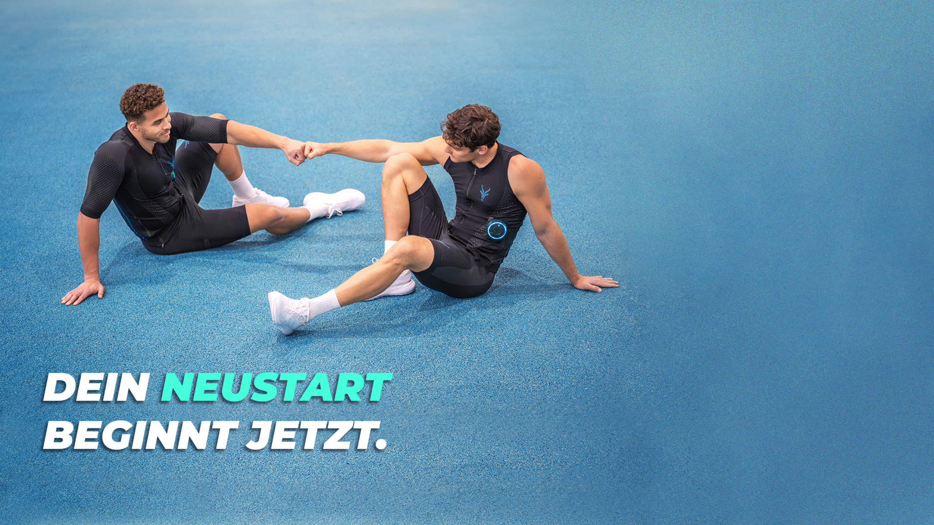 Zwei Männer in schwarzen EMS-Anzügen sitzen auf einer blauen Laufbahn und geben sich einen Fistbump. Text im Bild: „Dein Neustart beginnt jetzt."
