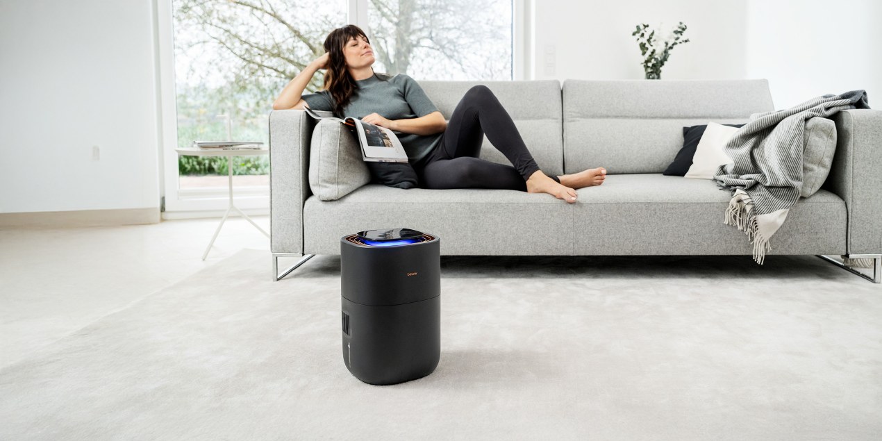 Junge Frau liegt auf dem Sofa und erholt sich während das LB 300 Plus im Vordergrund in Betrieb isteriodenschmerzen