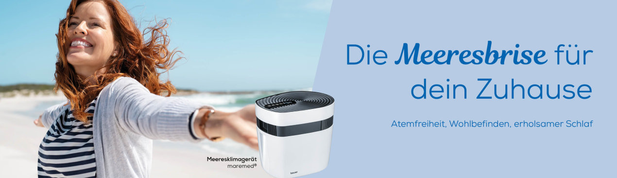 Modernes Meeresklimagerät im Wohnzimmer mit Slogan „Die Meeresbrise für dein Zuhause – Atemfreiheit, Wohlbefinden, erholsamer Schlaf