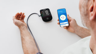 Mann nutzt App Beuerer Healthmanager Pro für sein Oberarm-Blutdruckgerät