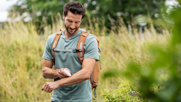 Mann verwendet Beurer BR 10 Insektenstichheiler beim Wandern
