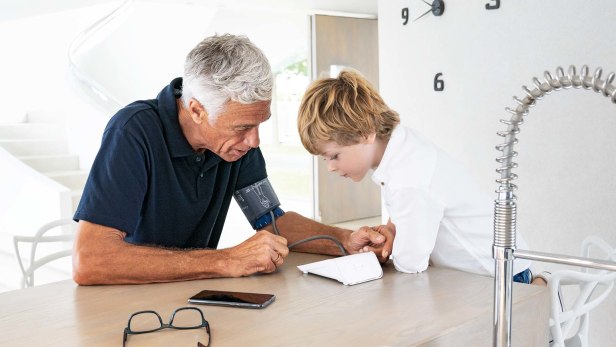 Un homme âgé et son petit-fils regardent le tensiomètre