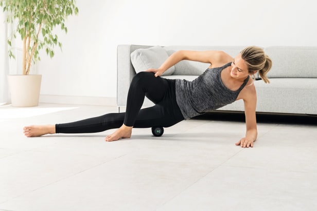 Woman using MG 35 Massage roller by Beurer Young woman lying with the side of her thigh on the MG 35 Massage roller by Beurer
