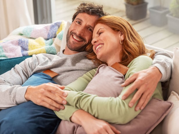 Paar mit HK 77 Heizkissen von Beurer Paar kuschelt auf Sofa mit HK 77 Heizkissen im Arm