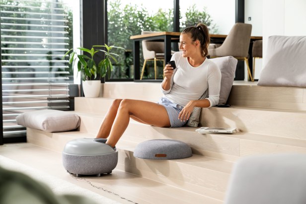 Une femme profite d'un massage des pieds avec le Beurer FM 120.