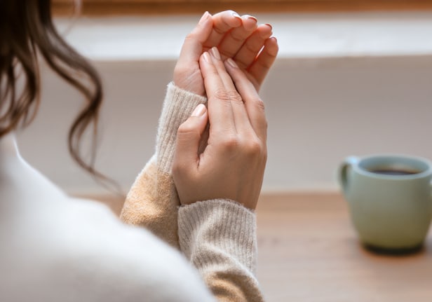 Une femme aux mains soignées ouvre une bouteille – Zoom sur la manucure et les soins