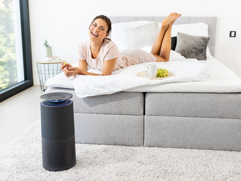 Le purificateur d'air purifie l'air pour le couple allongé sur le canapé du salon