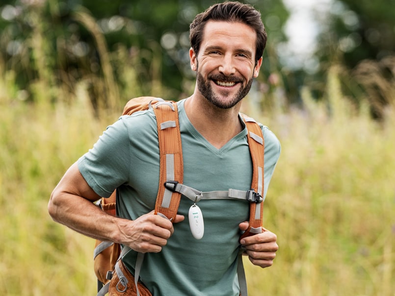 Mann beim Wandern mit dem Beurer BR 10 Insektenstichheiler am Rucksack
