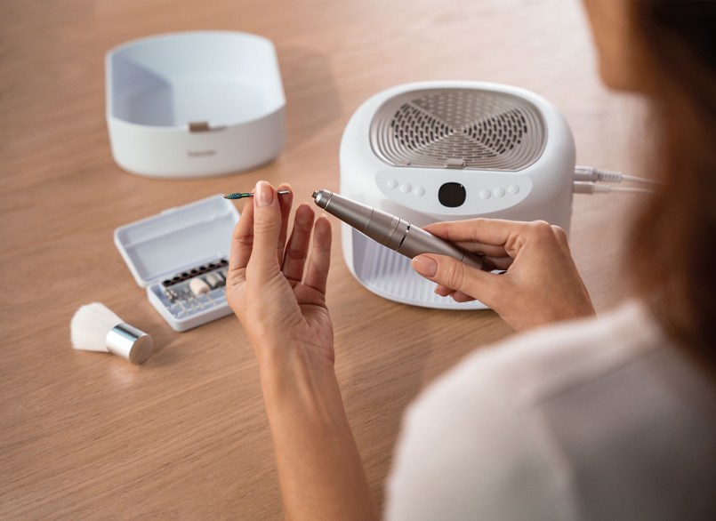 Dispositivo per manicure con fresa per unghie a fuoco, accessori sullo sfondo e accessori sullo sfondo