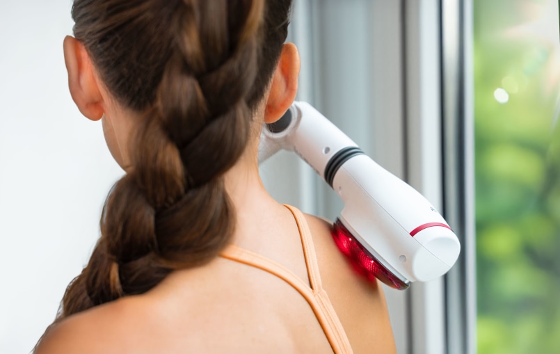 Zu sehen ist der Nacken einer Frau, die das MG 44 dort benutzt. Sie benutzt die Infrarotlicht Funktion ohne Massageaufsatz.