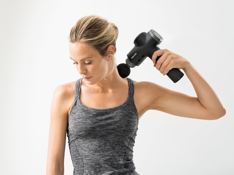 Frau wendet MG 180 Massagepistole am Nacken an