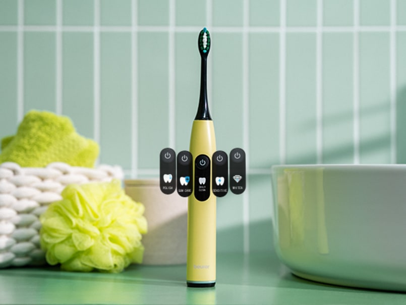 Die elektrische Zahnbürste SC 50 in der Farbe Splashy Lemon steht neben dem Waschbecken und die 5 Putzmodi sind abgebildet