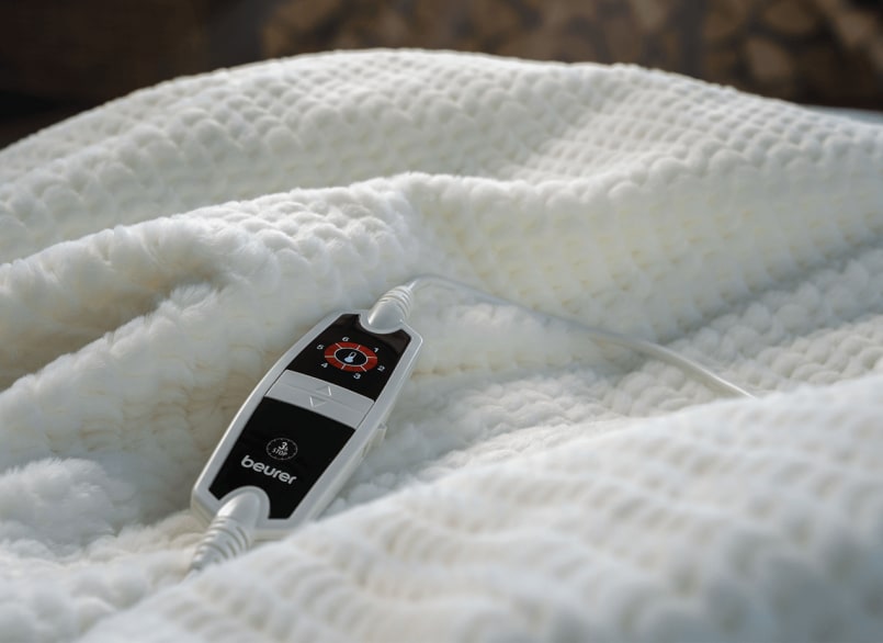 Produktbild der Beurer Heizdecke Helsinki in weiß, mit schwarz-weißem Schalter platziert auf der Decke