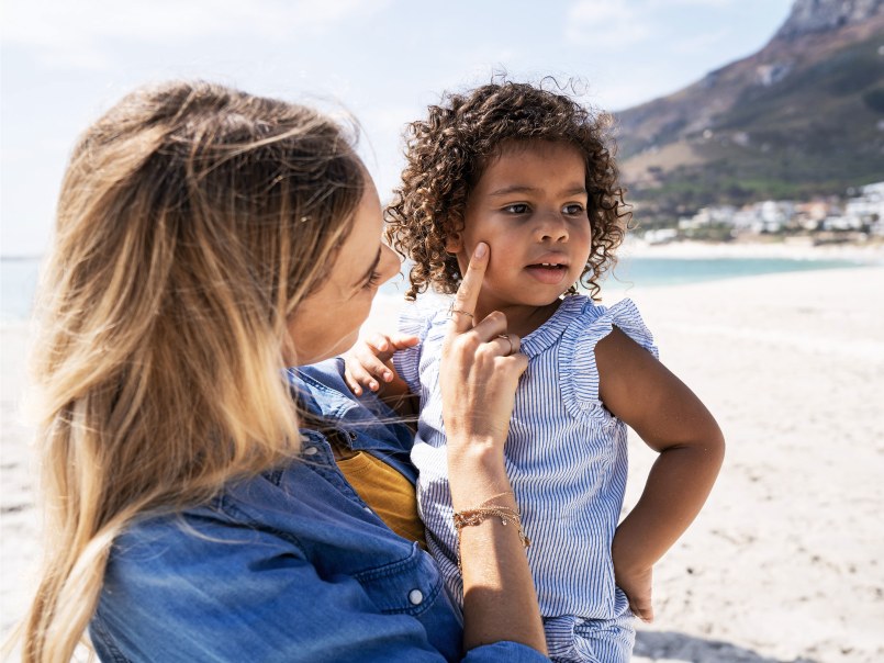 Frau mit Kind am Strand