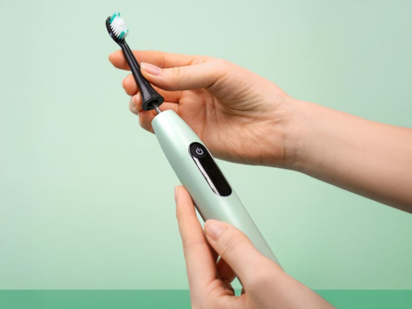 Die Beurer SC 50 in der Farbe Peppermint wird vor einem gleichfarbigem Hintergrund in zwei Händen gehalten