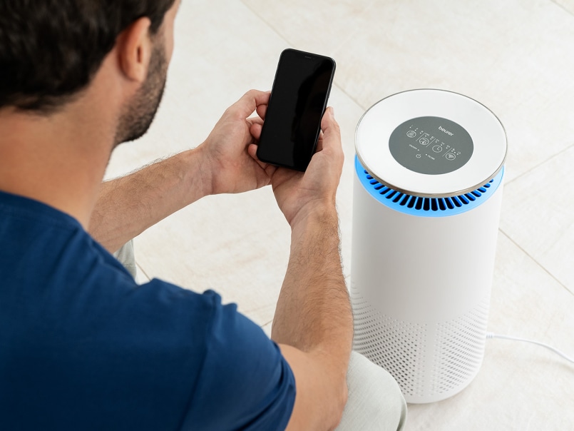 Schulter von einem jungen Mann der zugewendet zu LR 400 sitzt und ein Smartphone in den Händen hält.