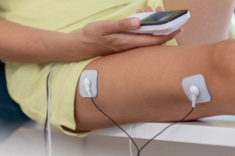 Ausschnitt von einem Frauen Bein und es sind 2 Elektroden am Bein befestigt.